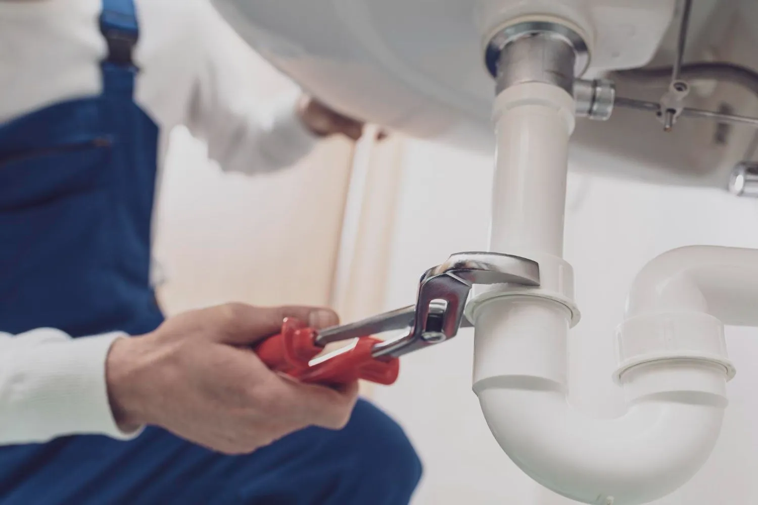 Professional plumber fixing a home sink